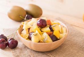 fruits tranchés mélangés dans un bol en bois photo