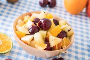 fruits tranchés mélangés dans un bol en bois photo