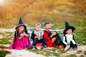 Jeune des gamins tour ou traiter pendant Halloween . les enfants sont séance sur le route dans Halloween déguisements. photo