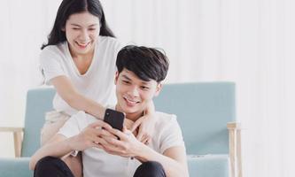 jeune couple regardant le téléphone avec une expression heureuse photo