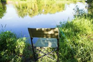 fauteuil pour pêche sur le lac. pêche barre dans le l'eau photo