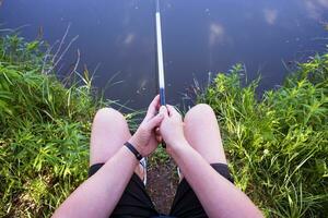 Jeune gars pêche sur une Lac séance dans une chaise photo