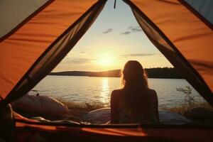 Jeune femme séance dans tente et à la recherche à Lac à le coucher du soleil. camping concept ai généré photo