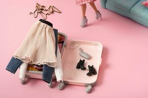 une lot de vêtements dans une valise, bagage avec panneaux. Voyage et vacances concept. de poupée monde. photo