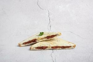 sandwich avec saucisse et fromage sur une gris Contexte. rue nourriture minimaliste photo