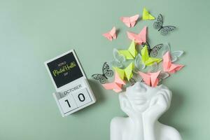 octobre dix est monde mental santé journée. tête figurine avec papillon remplissage photo