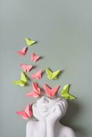 mental santé concept. une figurine de une tête avec papillons sur une coloré Contexte. photo