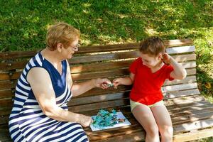 grand-mère et petite fille dans le parc sur une banc collecte puzzle photo