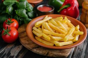 frites fraîches savoureuses et sauce rouge sur une planche à découper en bois photo