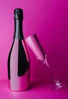 Champagne bouteille avec verre sur rose Contexte photo