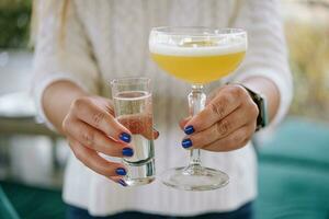 verre de étoile martini dans le mains de une fille photo