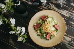 moyen rare rôti du boeuf salade avec vert mélanger et du vin photo