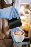 Lait mousse versé dans une tasse à forme une parfait cappuccino photo