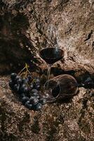 bouquet de les raisins avec une verre de du vin dans une la grotte photo