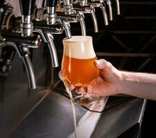 barman verser Frais Bière dans verre dans pub photo
