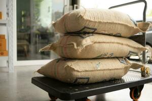 café des haricots Sacs de toile de jute sur une chariot dans une café des haricots entrepôt photo