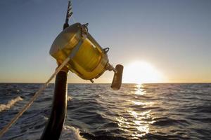 canne à pêche sur fond de coucher de soleil se bouchent photo