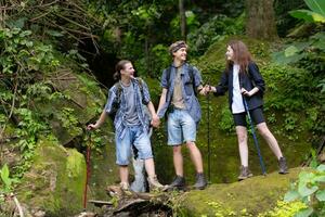 groupe de Jeune gens randonnée dans le forêt. Voyage et aventure concept. photo