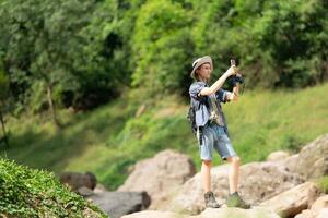 Jeune homme avec sac à dos randonnée dans le forêt. actif mode de vie concept. photo
