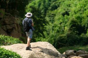 Jeune homme avec sac à dos randonnée dans le forêt. actif mode de vie concept. photo