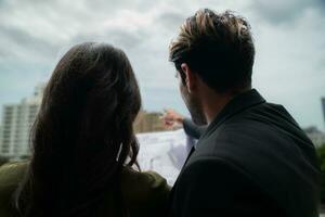 homme d'affaire et femme d'affaires discuter projet sur le balcon de Bureau bâtiment. photo