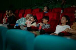 asiatique mère et fille en train de regarder film dans cinéma. famille temps concept. photo