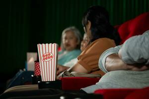 cinéma concept. gens en train de regarder film à cinéma boisson l'eau et en mangeant pop corn photo