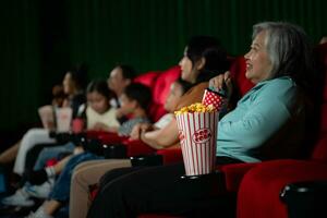 asiatique mère et fille en train de regarder film dans cinéma. famille temps concept. photo