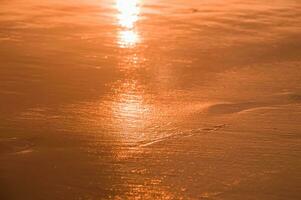 l'eau et le sable à le plage dans le coucher du soleil temps photo