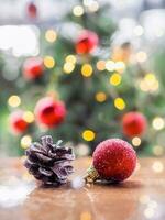 proche en haut de pommes de pin et rouge Balle avec Noël lumière bokeh Contexte. joyeux Noël et content Nouveau année 2024 photo