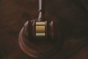 concept de justice et de droit. juge masculin dans une salle d'audience avec le marteau, travaillant avec, clavier d'ordinateur et d'accueil, lunettes, sur table à la lumière du matin photo