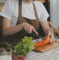 délicieux fruit et des légumes sur une table et femme cuisson. femme au foyer est Coupe vert concombres sur une en bois planche pour fabrication Frais salade dans le cuisine. photo