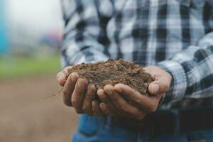 symbole cœur Terre journée. poignée de saleté mains cœur forme. ferme biologique Terre. agriculteur mains sol sol Terre saleté jardin sol ferme sol. Masculin mains plein de fertile terre champ agriculture concept photo