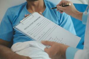 proche en haut de médecin séance sur chevet de Masculin patient dans hôpital photo