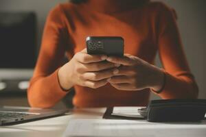 femme d'affaires asiatique utilisant un ordinateur portable et travaillant au bureau avec un document de calculatrice sur le bureau, faisant la planification en analysant le rapport financier, l'investissement dans le plan d'affaires, le concept d'analyse financière. photo