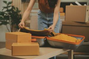 magnifique Jeune couple dans l'amour ayant amusement déballage des choses de papier carton des boites tandis que en mouvement dans ensemble dans leur Nouveau appartement photo