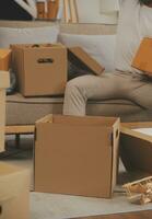 magnifique Jeune couple dans l'amour ayant amusement déballage des choses de papier carton des boites tandis que en mouvement dans ensemble dans leur Nouveau appartement photo