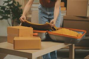 magnifique Jeune couple dans l'amour ayant amusement déballage des choses de papier carton des boites tandis que en mouvement dans ensemble dans leur Nouveau appartement photo