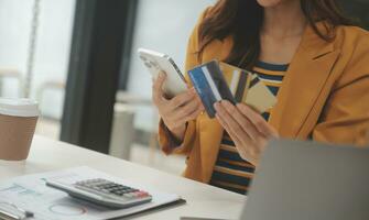 femmes en portant crédit carte et en utilisant les smartphones à maison.en ligne achats, l'Internet bancaire, boutique en ligne, paiement, dépenses argent, commerce électronique Paiement à le magasin, crédit carte, concept photo