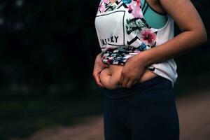 femmes corps graisse ventre. obèse femme main en portant excessif ventre graisse. régime mode de vie concept à réduire ventre et forme en haut en bonne santé estomac muscle. photo