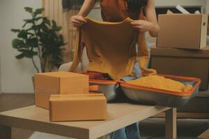 magnifique Jeune couple dans l'amour ayant amusement déballage des choses de papier carton des boites tandis que en mouvement dans ensemble dans leur Nouveau appartement photo