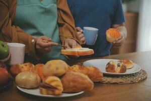 caucasien attrayant couple cuisson boulangerie avec fils dans cuisine à maison. content père de famille, mère et Jeune garçon ayant amusement dépenses temps ensemble en utilisant ingrédient fabrication nourriture. activité relation. photo