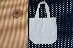 blanc coton sac sur une bleu et blanc polka point Contexte. photo