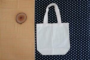 blanc coton sac sur une bleu et blanc polka point Contexte. photo
