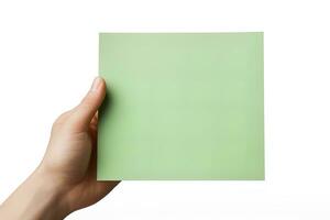 une Humain main en portant une Vide feuille de vert papier ou carte isolé sur une blanc Contexte. ai généré photo