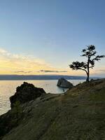 Roche chamanka sur olkhon île à coucher de soleil, Lac baïkal, Russie photo