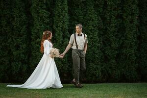 mariage marcher de le la mariée et jeune marié dans une conifère photo