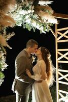 la mariée et jeune marié contre le toile de fond de un soir mariage cambre photo