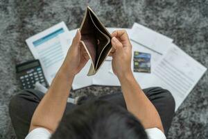 stressé et mal de crâne homme avec grand factures ou factures non argent à Payer à les dépenses et crédit carte dette. pénurie, financier problème, la faillite, hypothèque, prêt, faillite, pauvre, vide portefeuille photo