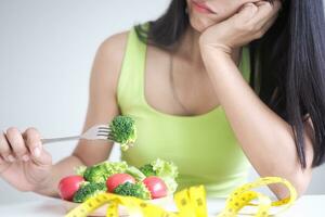 svelte corps asiatique femmes très ennuyé régime nourriture, suivre un régime femelle choisir faible calories nourriture pour régime. bien en bonne santé aliments. poids perdre, équilibre, contrôle, réduire graisse, routines, exercer, corps forme photo